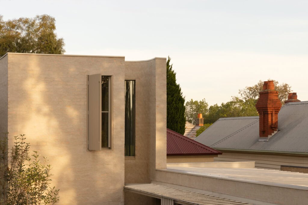 Oval house with sleek, curved architecture and large windows.