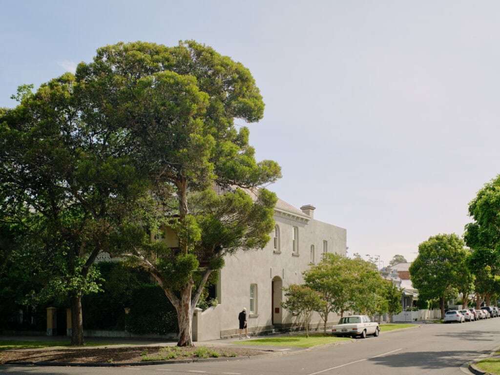 Eleanor House surrounded by large trees and a quiet street scene.