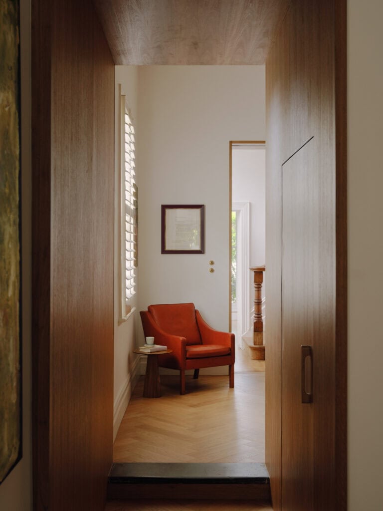 Cozy reading nook with orange armchair and side table in a bright room.