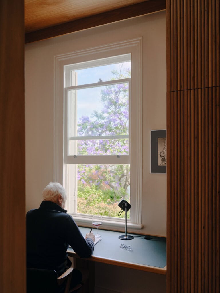 Interior scene at Eleanor House with a person by the window and scenic view outside.
