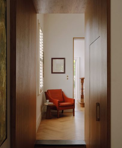 Cozy reading nook with orange armchair and side table in a bright room.